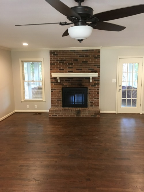 A room with a fireplace and a ceiling fan.