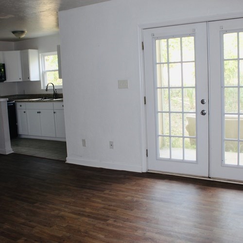 A kitchen with white cabinets and a black countertop.