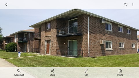 A brick building with a balcony on the second floor.