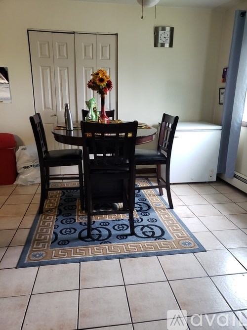 A dining room with a table and chairs.