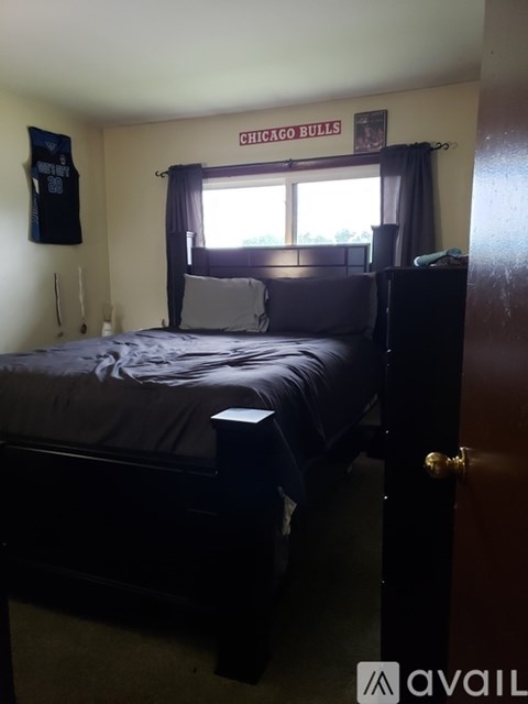 A bedroom with a bed, dresser, and a Chicago Bulls banner on the wall.