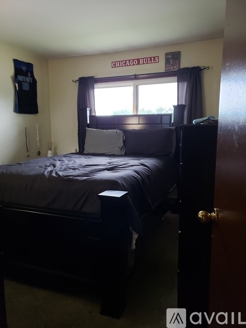 A bedroom with a bed, dresser, and a Chicago Bulls banner on the wall.