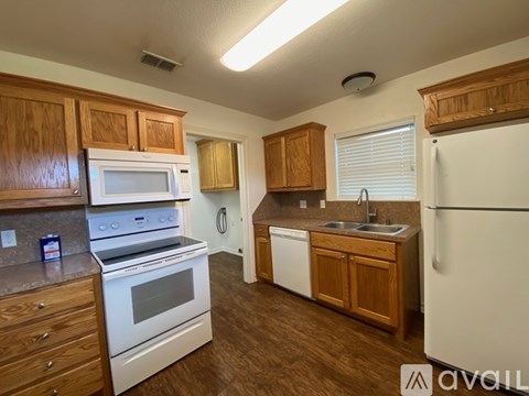 A kitchen with wooden cabinets and white appliances.
