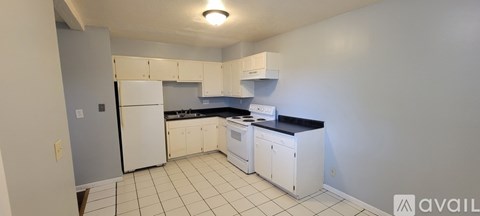 A kitchen with white appliances and cabinets.