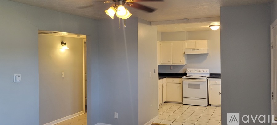 A kitchen with white appliances and cabinets.