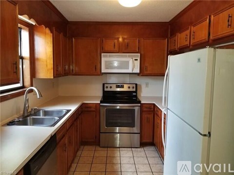 A kitchen with wooden cabinets and a white refrigerator.