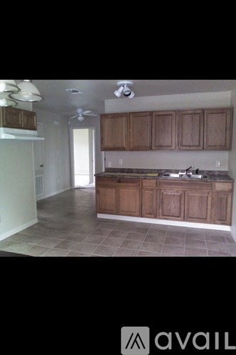 A kitchen with wooden cabinets and a tiled floor.