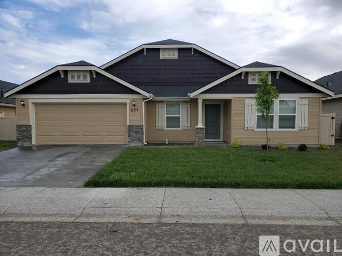 A two-story house with a garage and a driveway.