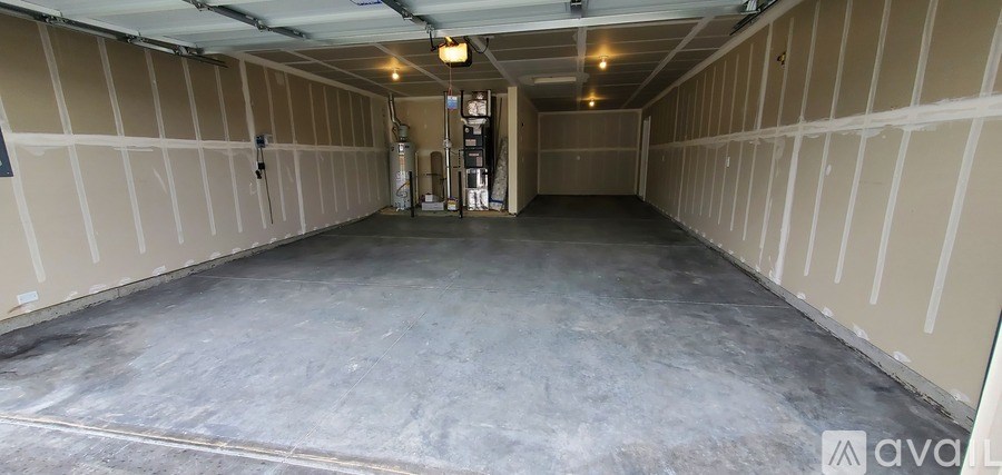 A spacious garage with a concrete floor and walls covered in insulation.