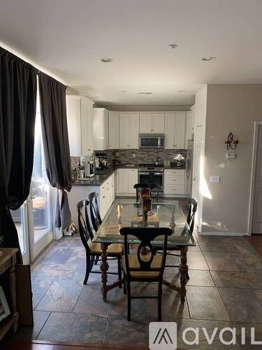 A kitchen with a table and chairs in front of a window.