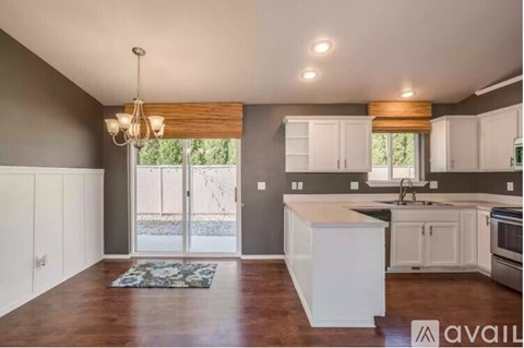 A kitchen with white cabinets and a wooden island.