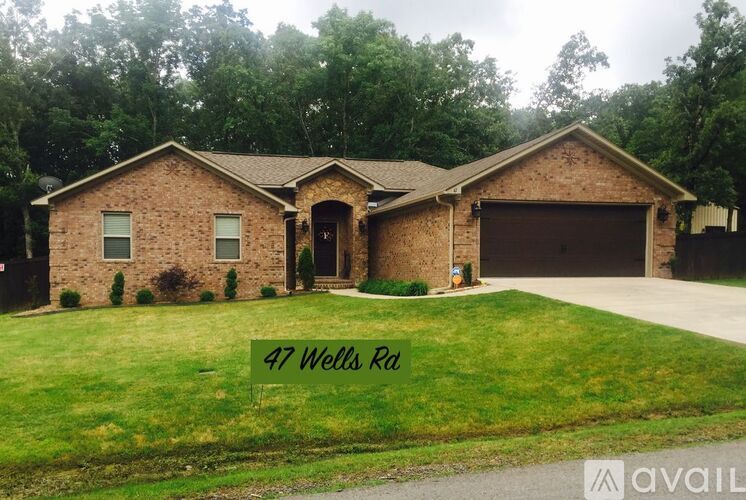 A house with a sign that says 47 Wells Rd in front of it.