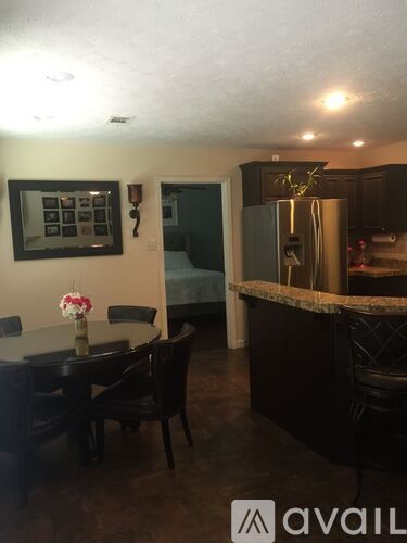 A kitchen with a table and chairs in the foreground.
