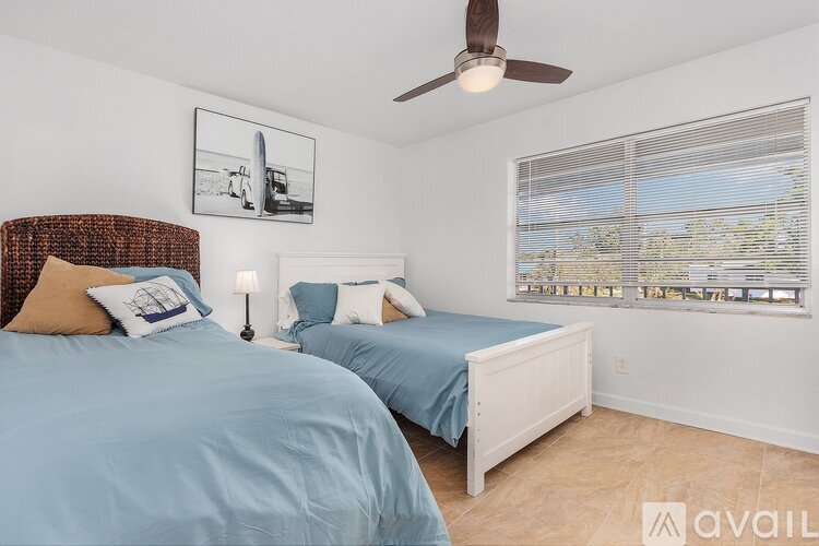 A bedroom with two beds and a ceiling fan.