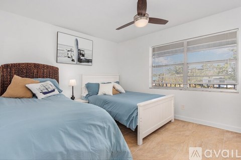 A bedroom with two beds and a ceiling fan.