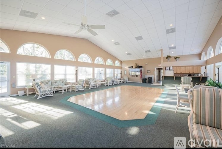 A spacious room with a basketball court in the middle and chairs around it.