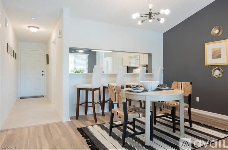A dining room with a white table and chairs.