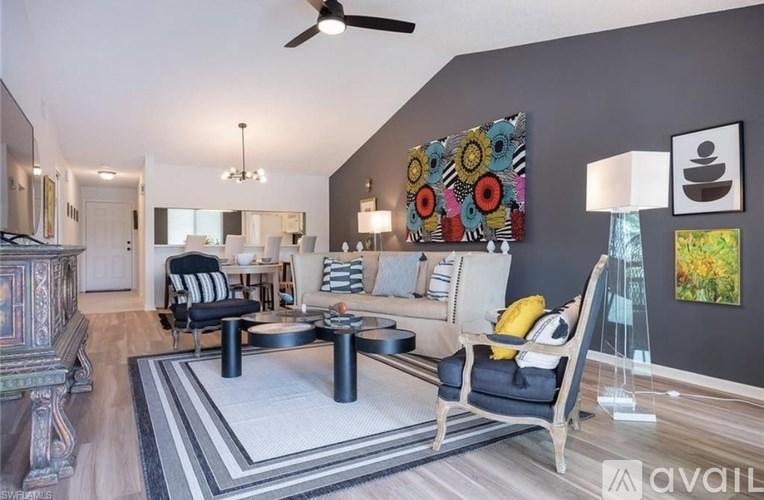 A living room with a black and white striped chair and a grey couch.