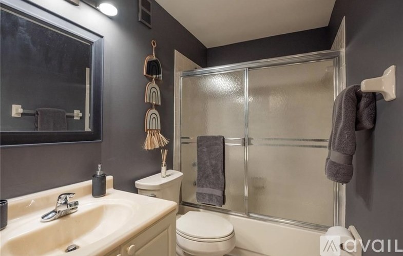 A bathroom with a toilet, sink, and shower.