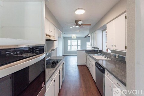 A kitchen with white cabinets and a black stove top oven.