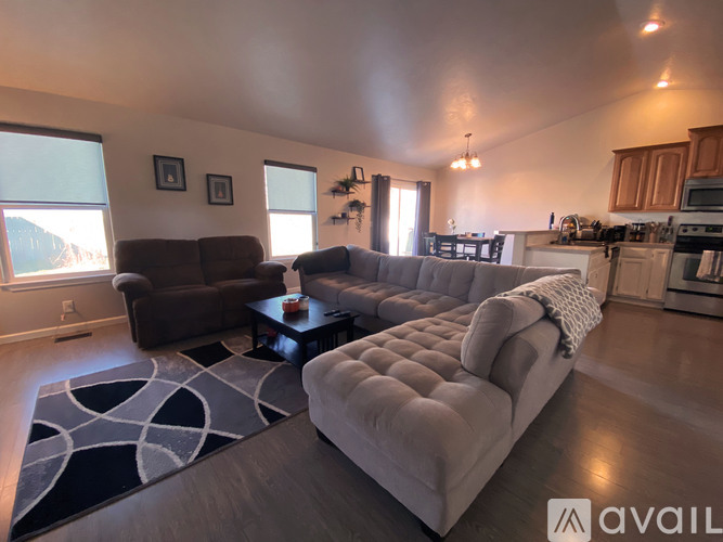 A living room with a grey couch and a brown armchair.