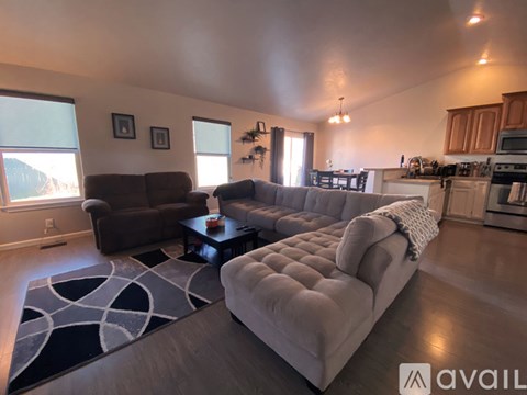 A living room with a grey couch and a brown armchair.