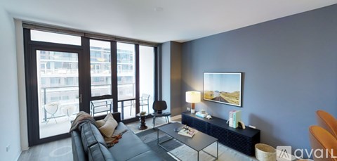 A living room with a black couch and a large window.