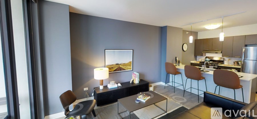 A modern kitchen with a bar stool and a dining table.