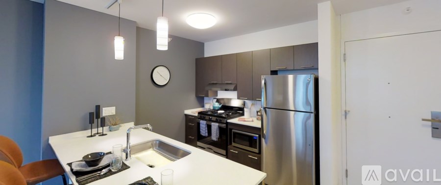 A kitchen with a refrigerator, sink, and stove.