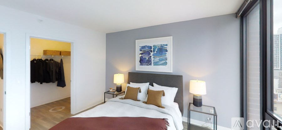 A bedroom with a large bed and a painting on the wall.