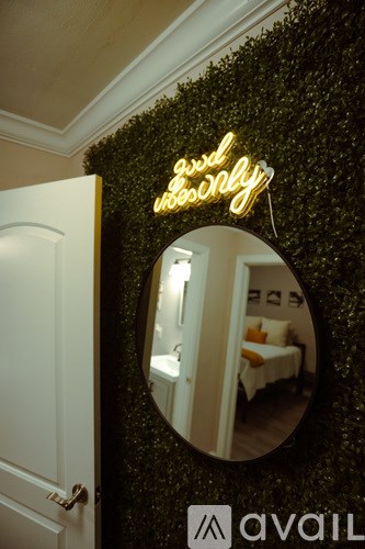 A mirror reflects a room with a bed and a sign that says "Good Morning".