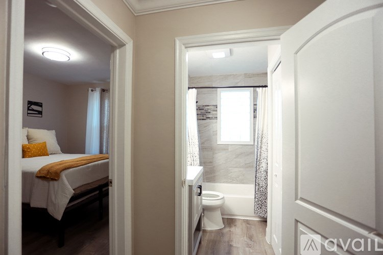 A bedroom with a bed, a toilet, and a bathroom with a shower.