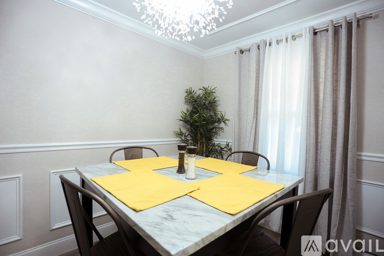 A dining table with a yellow placemat and a potted plant on it.