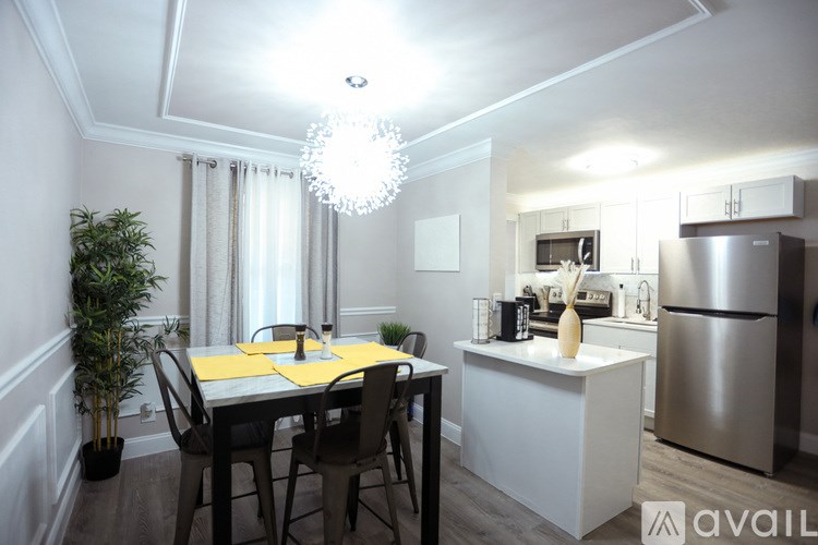 A modern kitchen with a dining table set for two.