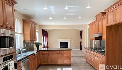 A kitchen with wooden cabinets and a stainless steel refrigerator.