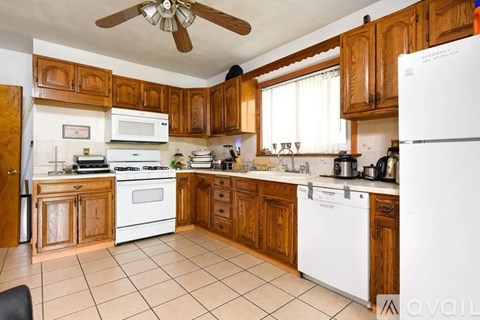 A kitchen with wooden cabinets and white appliances.