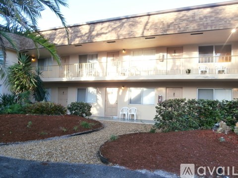 A building with a balcony and a garden in front.