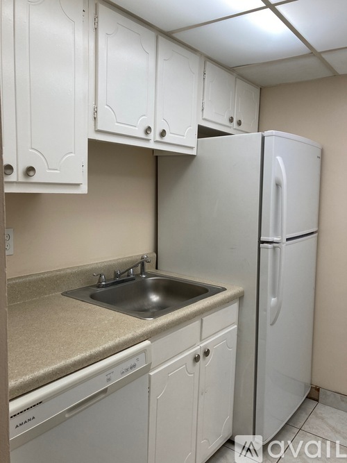 A kitchen area with white cabinets and a countertop.