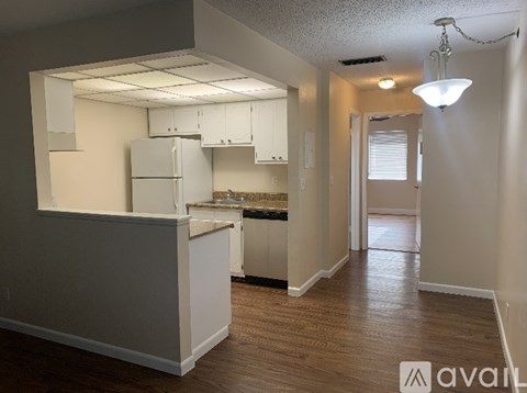A kitchen area with white cabinets and a countertop.