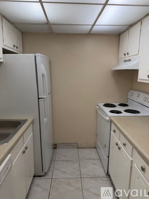 A kitchen with white cabinets and a countertop.