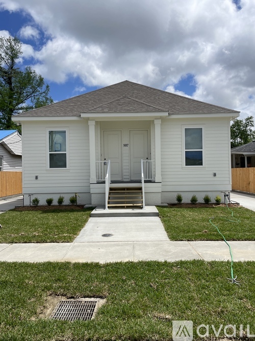 A white house with a grey roof and a small front porch.