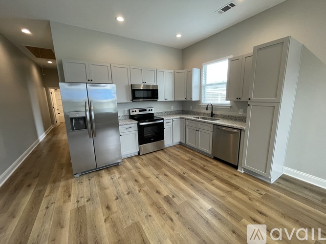 A kitchen with wooden floors and stainless steel appliances.