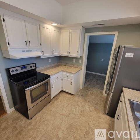 A kitchen with white cabinets and a black stove top oven.
