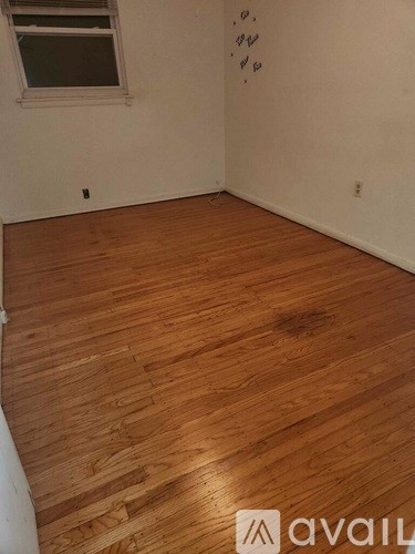A room with wooden flooring and a window.