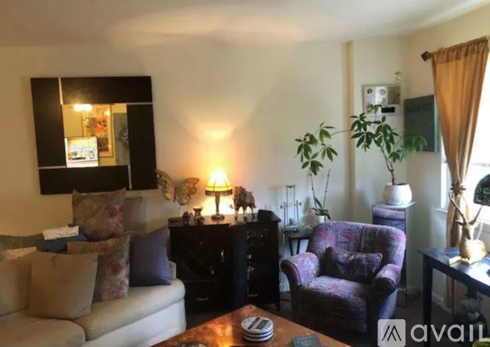 A living room with a couch, chair, and lamp.