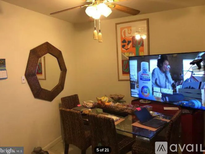 A living room with a TV on and a man on the screen.