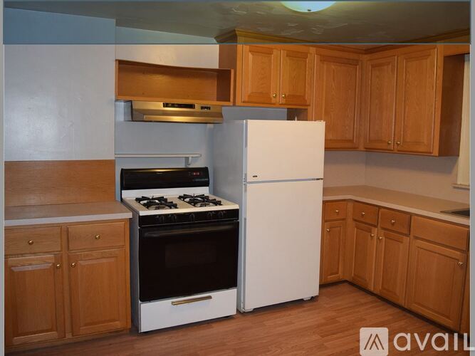 A kitchen with wooden cabinets and a white refrigerator.