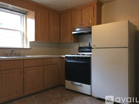A kitchen with wooden cabinets and a white refrigerator.