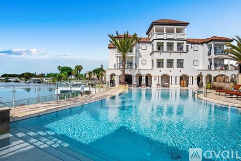 A large white house with a pool in front.