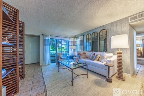 A living room with a glass table and a white couch.